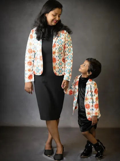 A loving look between a mother and her daughter. Their matching jackets add a fun, stylish touch to this sweet and candid moment.