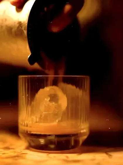 Another shot of a cocktail being prepared for a Christmas party, showcasing the rich amber color of the drink.