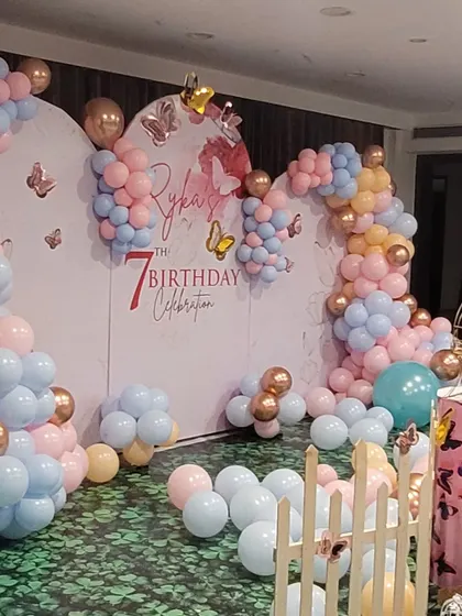 Another angle of the butterfly theme backdrop, showing the arching balloon garland and scattered butterfly decals that create a sense of depth and movement.