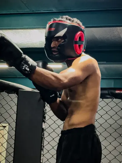 A fighter, focused and ready, wearing headgear for a sparring match. Safety is crucial in training, allowing us to go hard while minimizing injury.