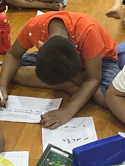 A student deeply engrossed in his calligraphy practice. This activity is excellent for improving concentration and handwriting.