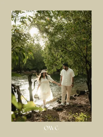 A romantic stroll through the woods. This save-the-date photo captures the couple hand-in-hand, surrounded by the beauty of nature.