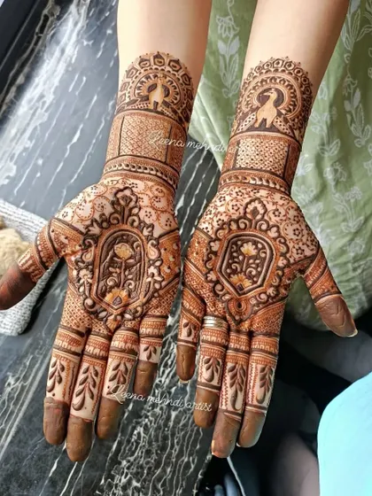 A closer look at a symmetrical bridal design, showcasing matching patterns on both hands. The artwork includes lotus figures, peacock motifs, and fine checkerboard patterns for a rich texture.