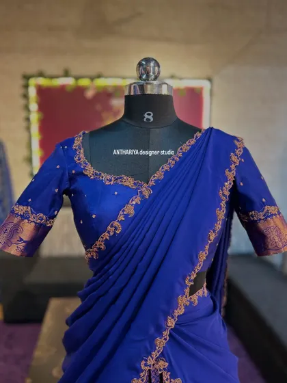Close-up of the royal blue blouse and draped davani, with delicate gold embroidery along the edges.