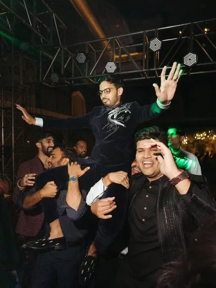The groom being lifted by his friends on the dance floor. These are the fun, unforgettable moments that define a great wedding party.