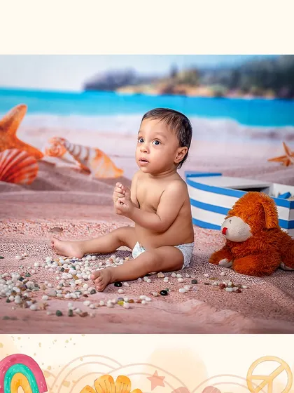 A thoughtful moment on the beach. This baby enjoys a quiet moment with his teddy bear on the sandy shores of our beach-themed set.