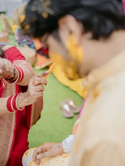 A playful moment where the bride's sister applies haldi to the groom. This candid shot captures the fun interactions between the two families.