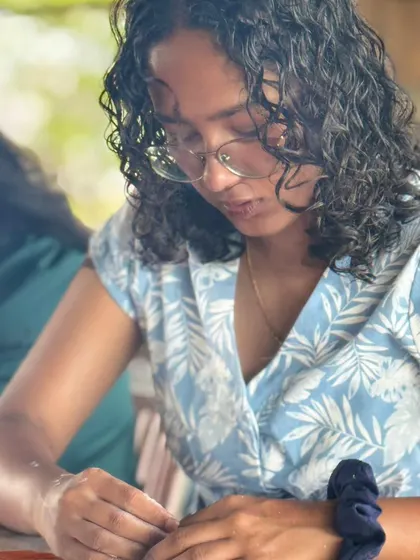A candid shot of a participant working on her project. Our goal is to create a culture where ideas spark and stories bloom face-to-face.