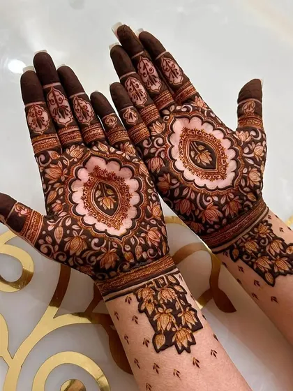 A beautiful mandala design on the palm with delicate floral patterns on the wrist. This is a popular choice for a modern yet traditional feel.