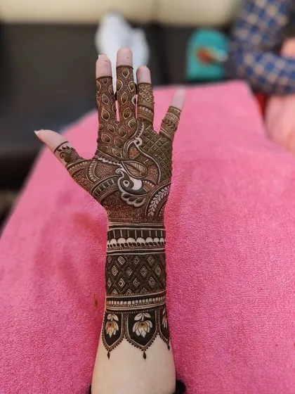 A beautiful back-hand design featuring a peacock on the palm and a lotus cuff on the wrist. The intricate details on the fingers complete this elegant look.