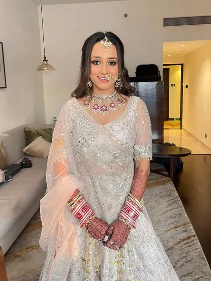 My bride Tanvi looking radiant in a stunning white mirror-work lehenga. I created a look with beautifully defined kohl-rimmed eyes and soft pink lips to complement her outfit.