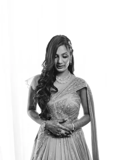 Another stunning black and white portrait of Simran. This shot captures her looking down, highlighting the details of her hair and makeup, and creating a moment of quiet reflection.