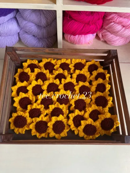 A crate full of sunflower heads, which can also be used as appliques or keychains.