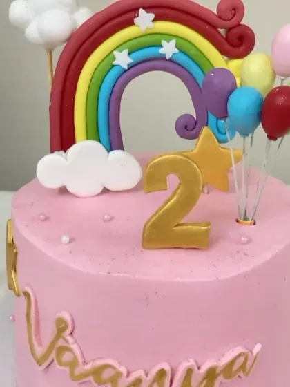 A close-up of the rainbow cake, showing the golden stars and personalized name.