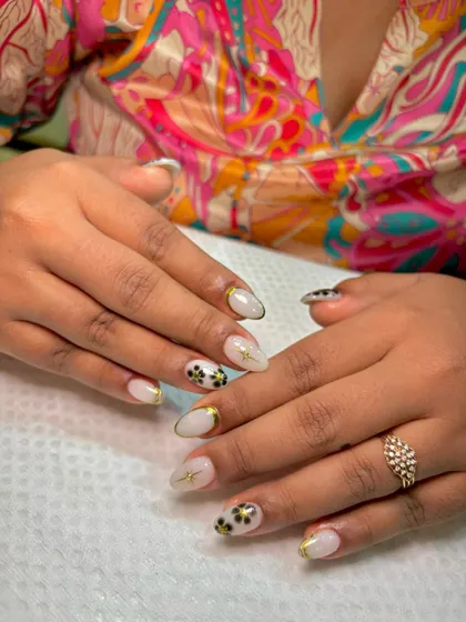 This photo shows the "blueming" nail art in a real-life setting. The design is subtle enough for everyday wear but has enough detail with the gold accents to feel special.