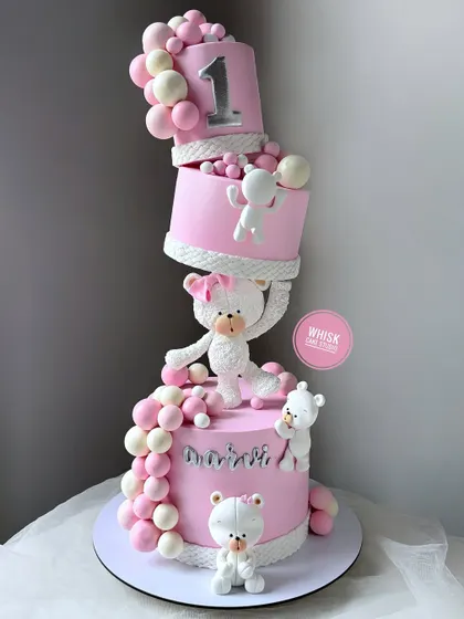A stunning topsy-turvy cake for a first birthday. This all-pink design features adorable teddy bears and gravity-defying tiers, creating a playful and impressive showpiece.