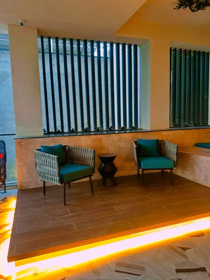 A cozy seating arrangement on the balcony, with comfortable chairs and subtle under-bench lighting creating a warm glow.