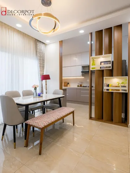 An open-concept design where the kitchen flows into the dining area. The wooden partition with built-in shelves adds a decorative touch while defining the space, creating a perfect setup for entertaining guests.