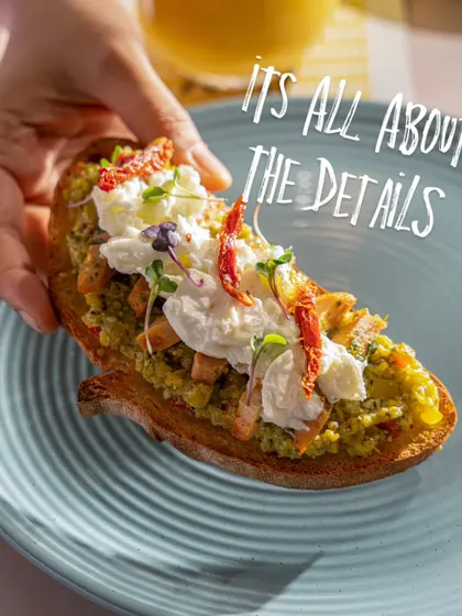 A close-up on a gourmet toast at Blue Tokai, emphasizing the details of the toppings. This shot highlights the quality and craft of their food menu.