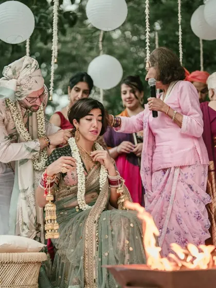 A cross-cultural couple participates in a traditional fire ceremony, blending their lives and families together.