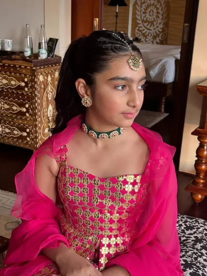 A beautiful portrait of the young client, showcasing her braided ponytail and traditional Indian jewelry.
