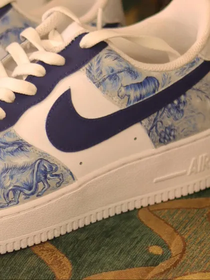 A side view of the Dior-inspired custom sneakers. The deep blue paint stands out beautifully against the crisp white leather of the Air Force 1s.