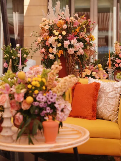 A close-up of the yellow sofa and floral decor, highlighting the warm, sunny color palette of the Mehendi.