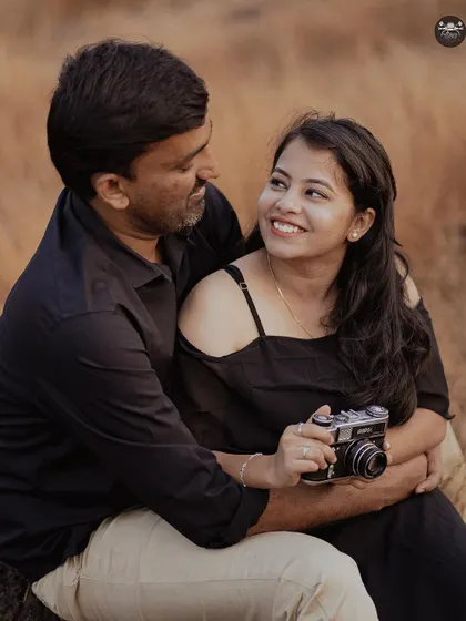 A themed shoot in a field with a vintage camera prop. This is a great idea for couples who share a love for photography or vintage aesthetics.
