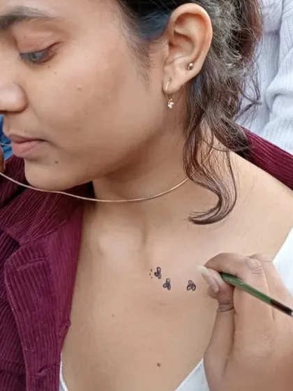 Tiny playing card suits painted on the collarbone. It's the small, personal details that make body art so much fun.