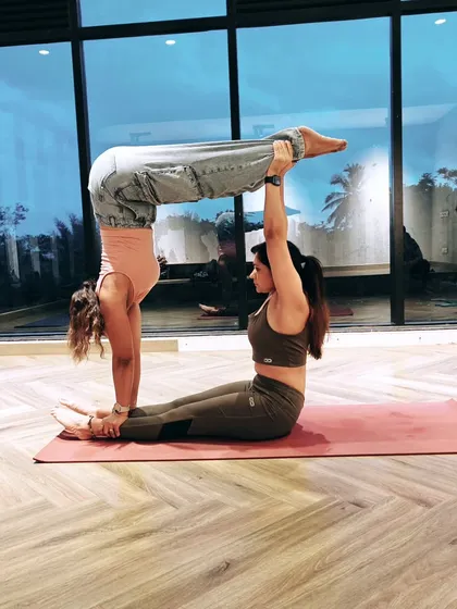The hardest part of practice isn't the pose, it's the pressure. In partner yoga, we learn to let go of that pressure and simply support each other. This L-sit handstand is a testament to trust.