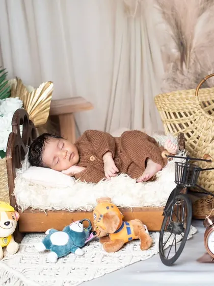 A wider shot of the newborn's bedroom setup, complete with a toy guitar and bicycle.