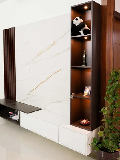 A close-up of the vertical display unit integrated into the TV console. The warm backlighting beautifully illuminates the decorative items on each shelf.