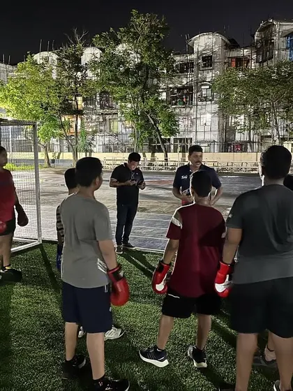 Our coach giving instructions to a group of young, aspiring boxers before a sparring session. We emphasize safety and strategy in all our training.