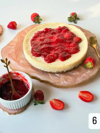 A detailed shot of the homemade strawberry compote being added to the Baked Yogurt Cheesecake. You can see the chunks of real fruit, a testament to my commitment to using fresh ingredients.