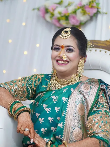 A beautiful engagement look in a traditional green saree. The makeup features a pop of color on the eyes and a warm lip, creating a fresh and celebratory feel.