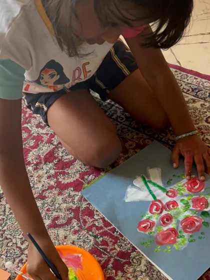 A young artist carefully adding details to her rose bouquet painting. The concentration and dedication are wonderful to see.