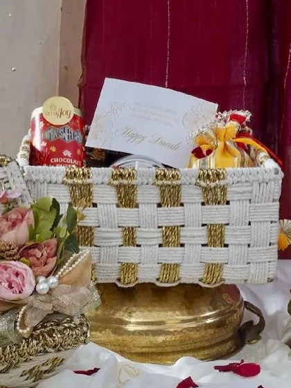 A closer look at the elegant white and gold woven basket from our Rang & Noor collection. It’s filled with chocolates, festive potlis, and a personalized Diwali card, ready to delight.