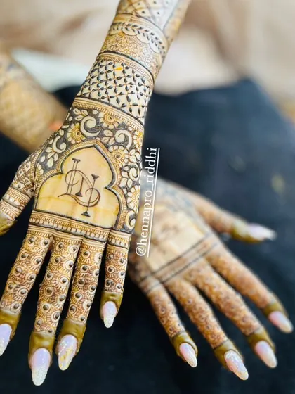 A beautiful shot of a modern engagement design. The focus is on the custom initial logo, which looks sharp and stylish, complemented by the bride's gorgeous nails.