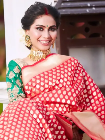 A happy and radiant bride. Her bright smile complements the classic reception makeup, featuring bold eyes, a traditional red bindi, and a beautiful gajra in her hair.