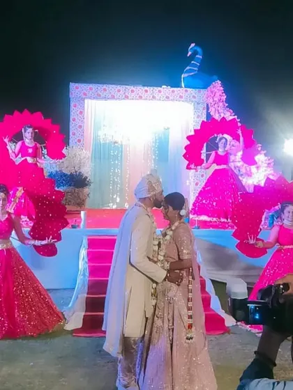 Even the Varmala ceremony can be a grand spectacle. Here, our dancers with elaborate peacock-themed props create a beautiful, symmetrical backdrop for the couple's special exchange.