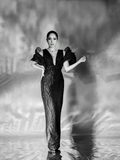 A powerful, centered, full-length portrait that combines classic glamour with a modern, artistic background effect.