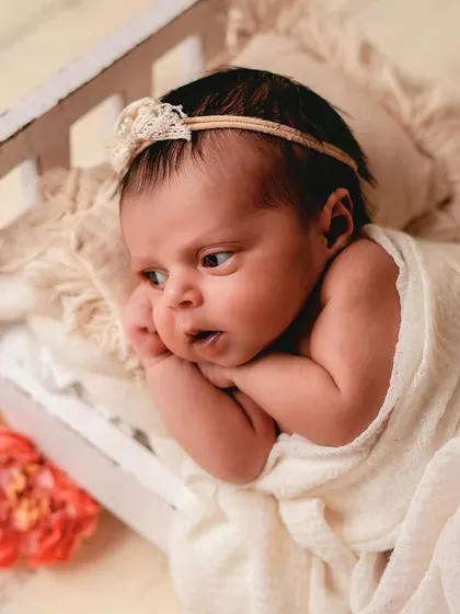 This tiny, rustic bed prop is a client favorite. It's perfect for capturing both sleeping and awake shots, like this one of a curious baby looking off to the side.