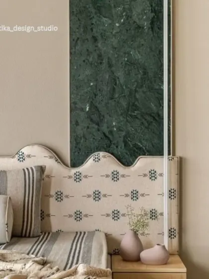 This image is a close-up of a custom headboard design where we combined different textures and materials. The patterned fabric of the headboard is set against a bold green marble panel, creating a unique and artistic statement piece.