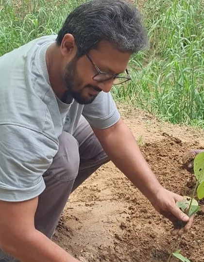 A volunteer from NTT DATA gets hands-on guidance from our team member while planting a native species at the Aravali Creek.