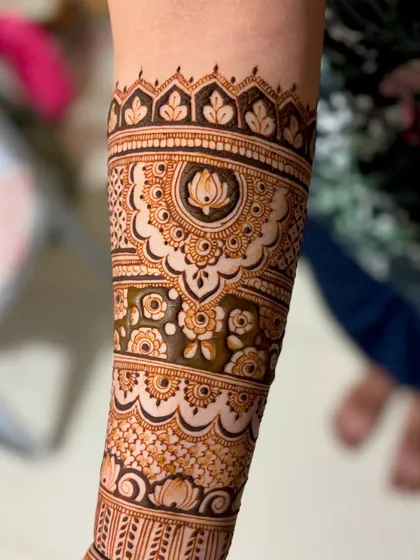 A close-up of the forearm, featuring a beautiful mandala and floral band.