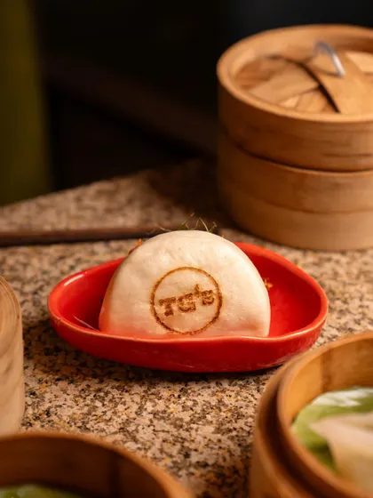 A unique shot focusing on a bao bun branded with the restaurant's logo. This highlights brand identity and attention to detail, making it a great marketing image.