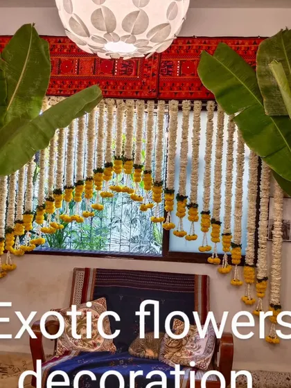 A classic South Indian style decoration. This window is framed with hanging strings of jasmine and marigolds, flanked by banana trees for an authentic and traditional feel.
