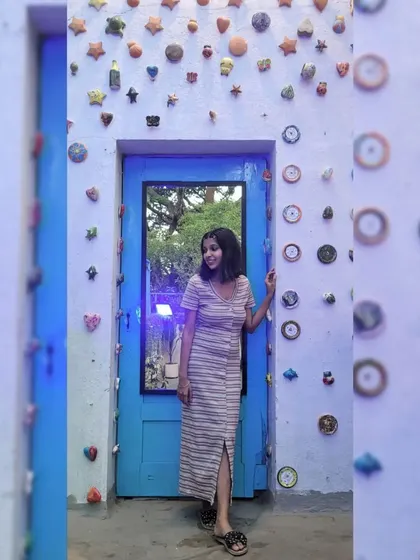 Posing against this quirky, artistic wall at a cafe in Koramangala, Bangalore. I love finding unique spots that inspire creativity.