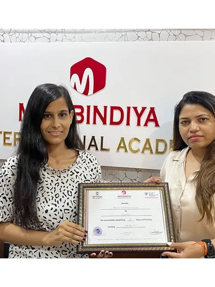 Another student proudly receives her certificate of completion, ready to embark on her professional path.