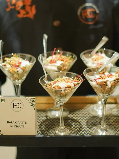 A modern take on a classic street food, our Palak Patte ki Chaat is served in elegant martini glasses. Crispy spinach leaves are topped with yogurt, chutneys, and spices for a delightful bite.